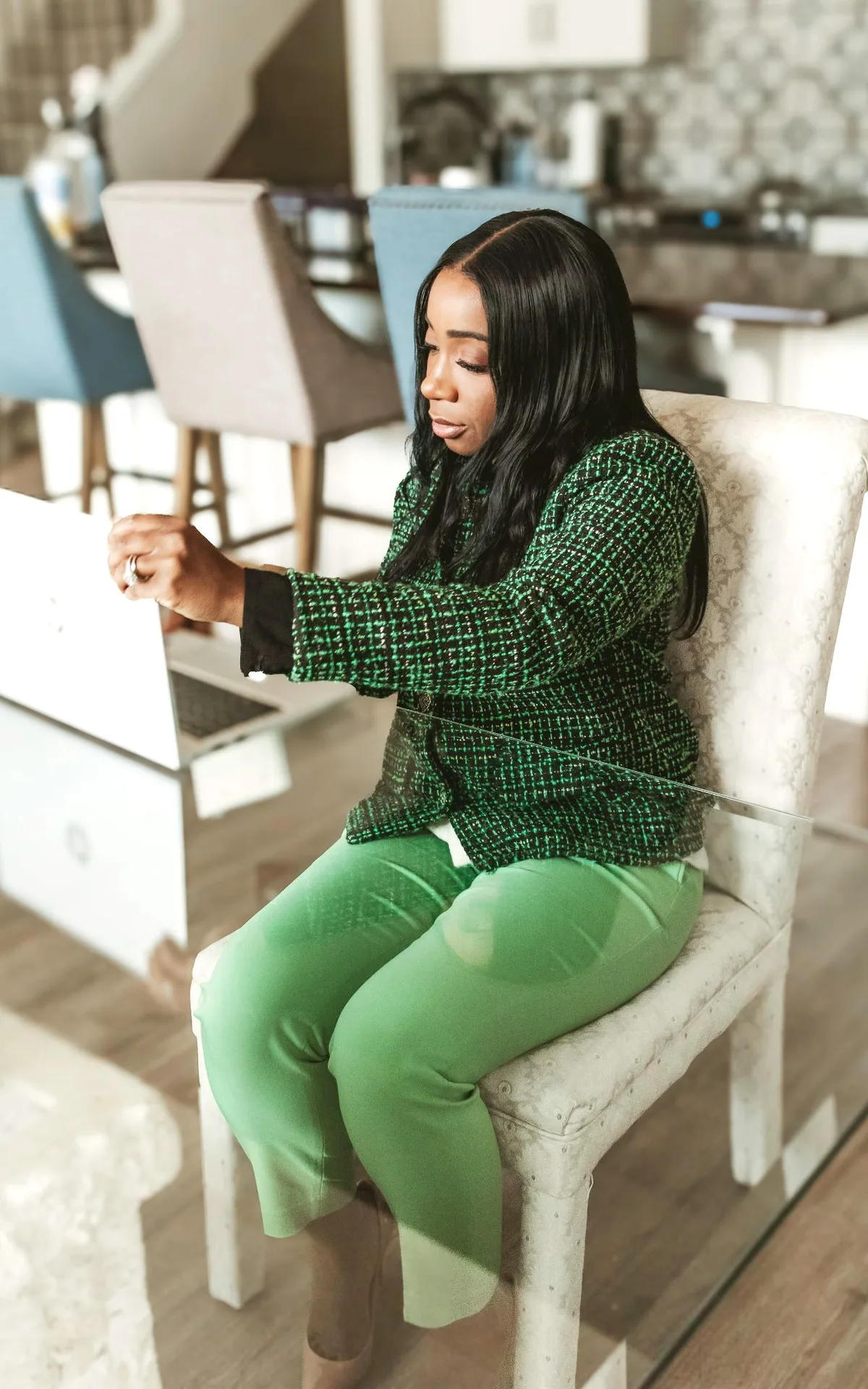 Oma Feboh seated at a desk, working at a laptop.