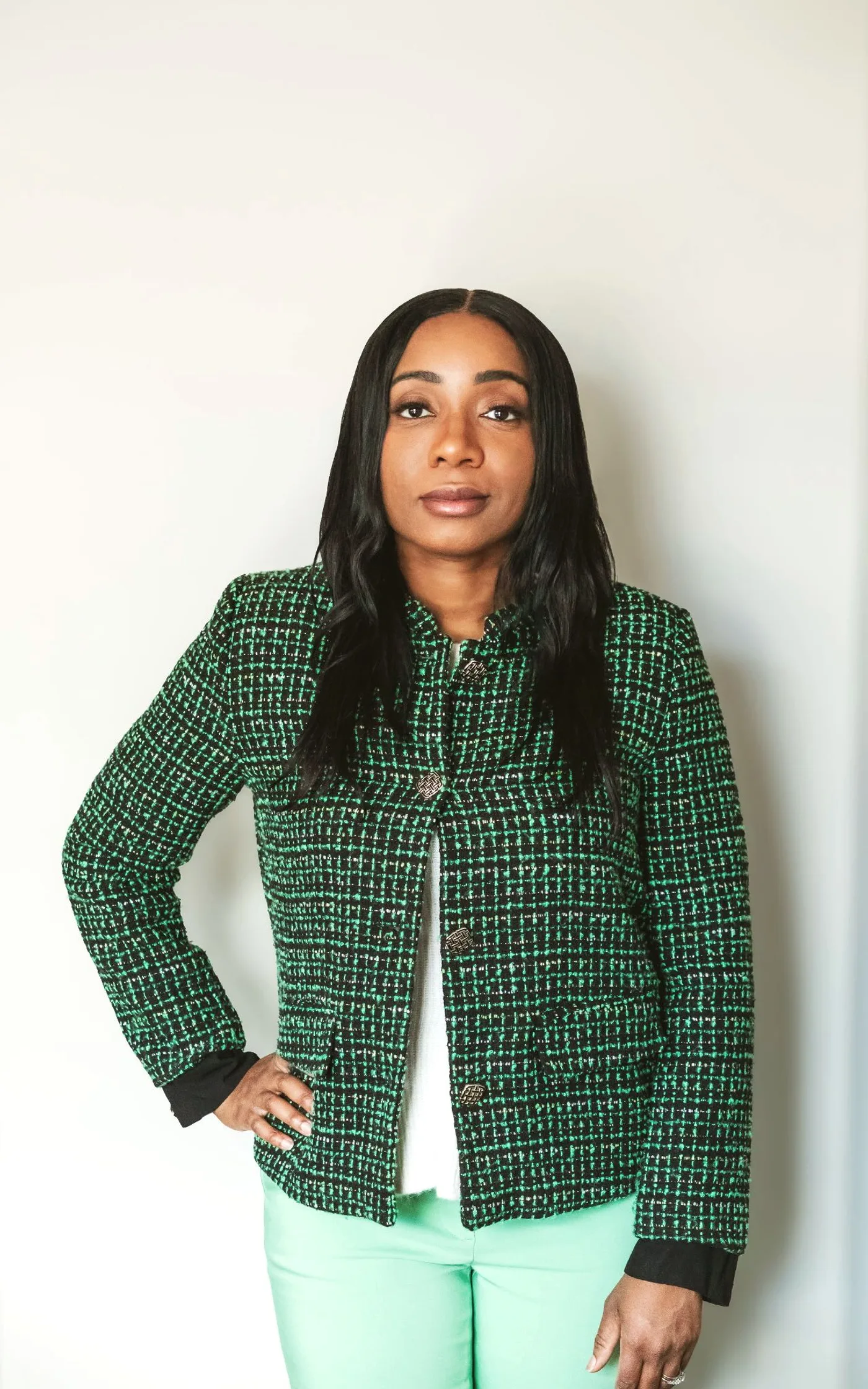Oma Feboh, mortgage broker, standing with one hand on her hip and looking directly at the camera.